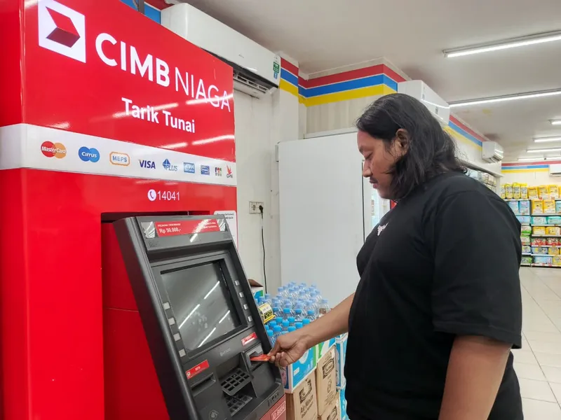 Nasabah CIMB Niaga sedang menggunakan layanan ATM
