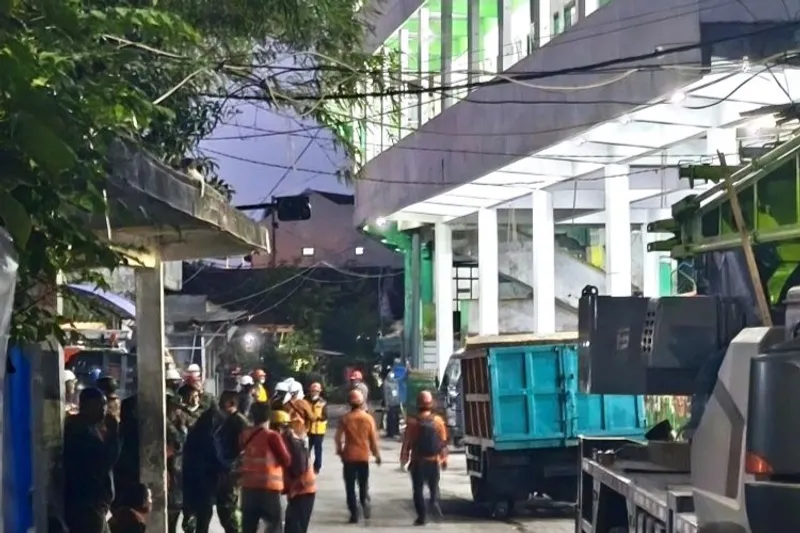 petugas SAR gabungan melintas di depan gedung Ponpes Al Khoziny Sidoarjo