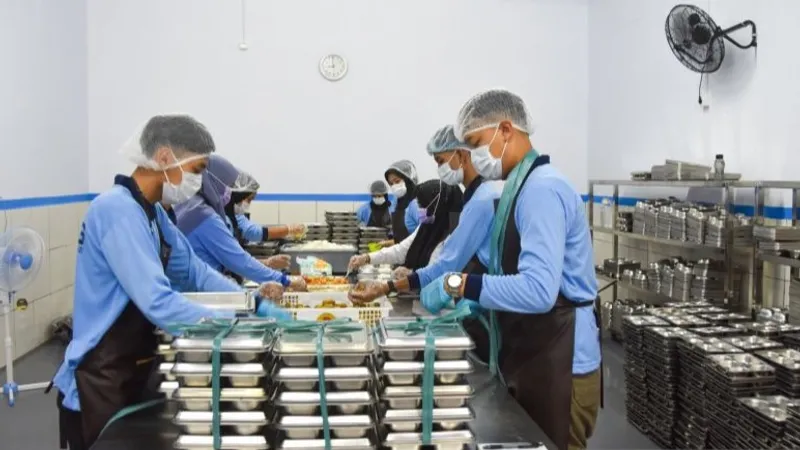 Pekerja menyiapkan paket makanan program makan bergizi gratis (MBG)