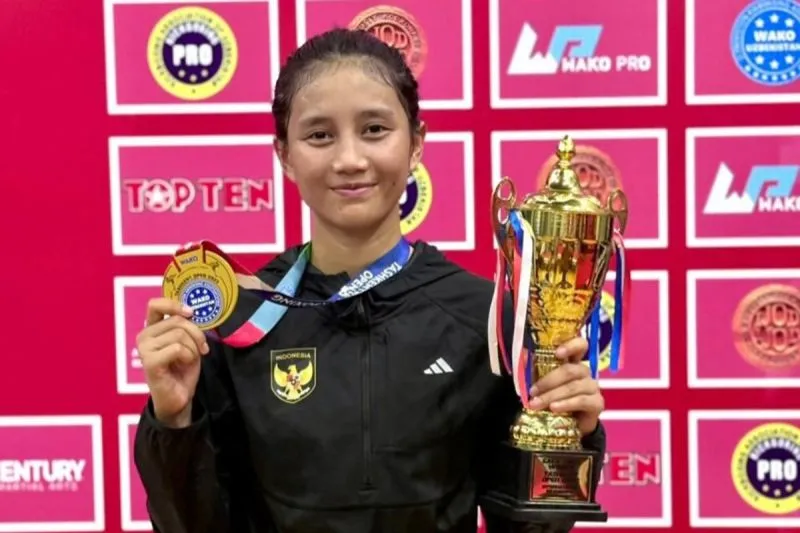 Bripda Aprilia berpose memegang medali emas dan trofi di ajang Uzbekistan Kickboxing World Cup 2025