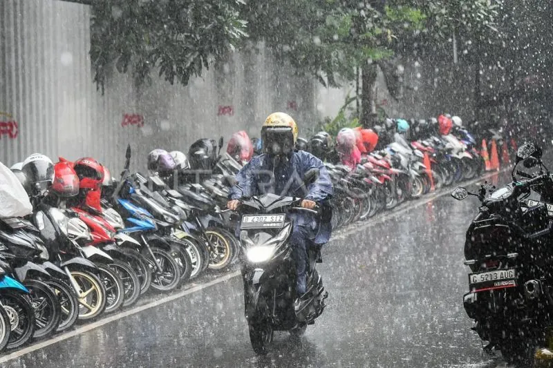 Pengendara sepeda motor menerobos hujan di kawasan Senopati, Jakarta