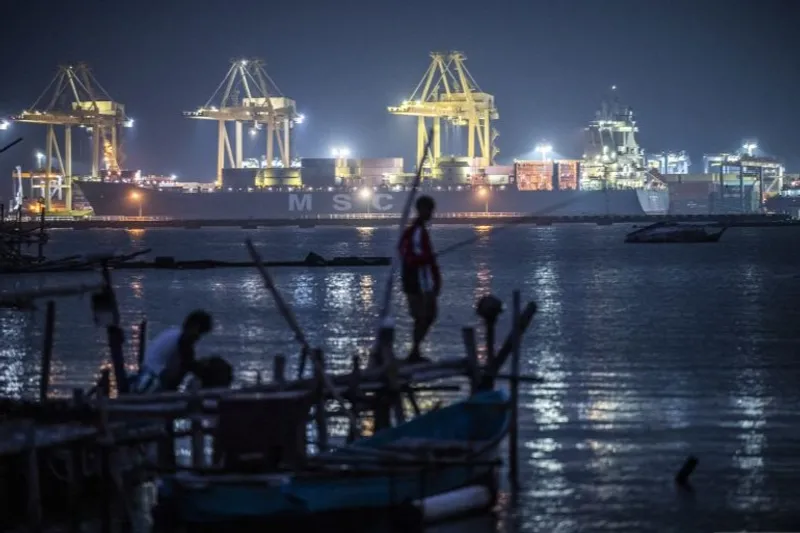 Dua warga memancing dengan latar Terminal Peti Kemas Pelabuhan Tanjung Emas