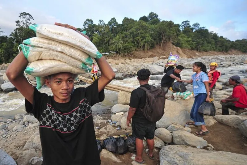 Warga bersiap menyeberangi jembatan darurat di atas aliran Sungai Nanggang 
