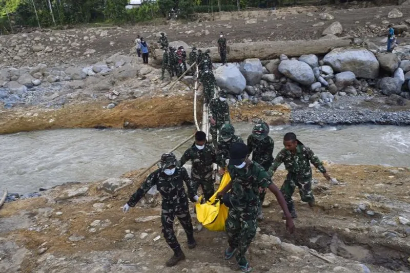 Prajurit Batalyon TP 897/Singalang menggotong jenazah korban meninggal 
