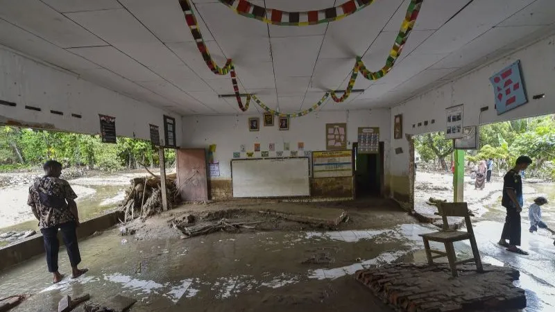 Warga berada di dalam ruang kelas yang rusak akibat banjir bandang di SDN 09 Bancah
