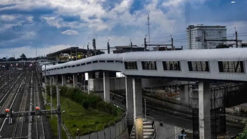 Sejumlah warga melintasi iembatan layang penyeberangan orang (skywalk) Stasiun Lebak Bulus Grab 