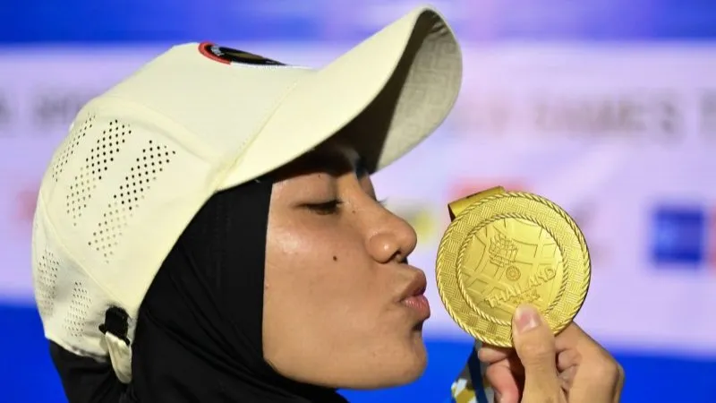 Atlet panjat tebing Indonesia Puja Lestari berpose dengan medalinya 