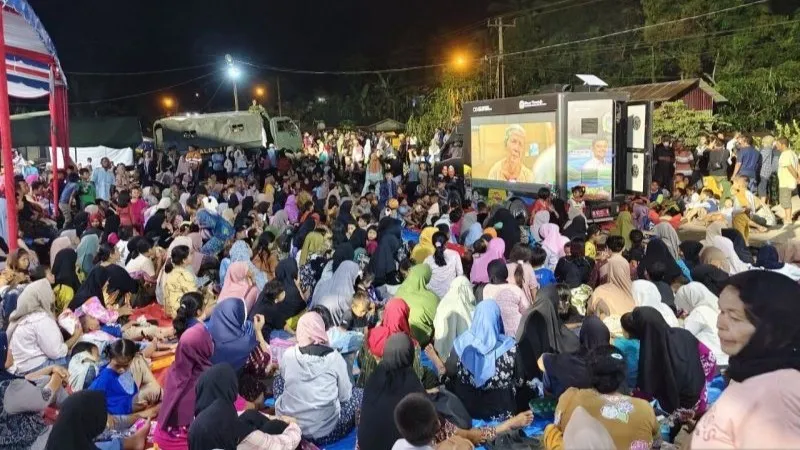 Warga menyaksikan film yang diputar di posko pengungsian Batu Hula Warga menyaksikan film yang diputar di posko pengungsian Batu Hula, Batang Toru, Tapanuli Selatan, Sumatera Utara, Rabu (31/12/2025). (ANTARA/Fathur Rochman)