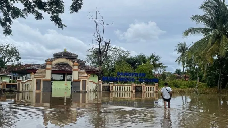 Warga berjalan ditengah banjir yang berlokasi di Kasemen, Kota Serang