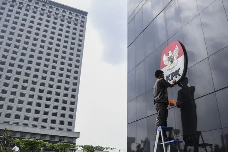 Pekerja membersihkan logo KPK, di Gedung Merah Putih