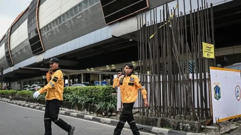 Petugas Dinas Bina Marga DKI Jakarta mengangkut besi tiang monorel 