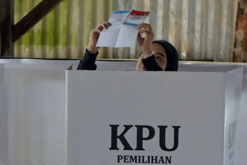 Warga memeriksa surat suara sebelum melakukan pencoblosan 