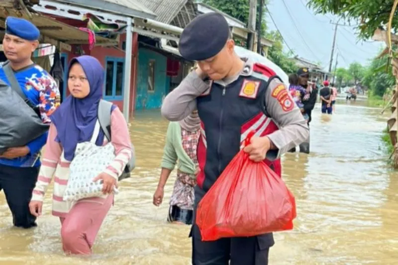 Anggota polisi membantu evakuasi warga terdampak banjir di Karawang