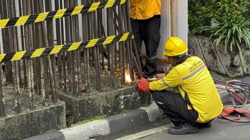 Seorang pekerja mulai membongkar tiang monorel di Jalan HR Rasuna Said