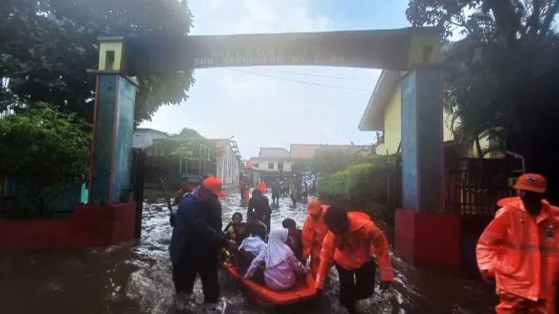 mengevakuasi pelajar lantaran sekolah terdendam banjir di SDN 05 Srengseng