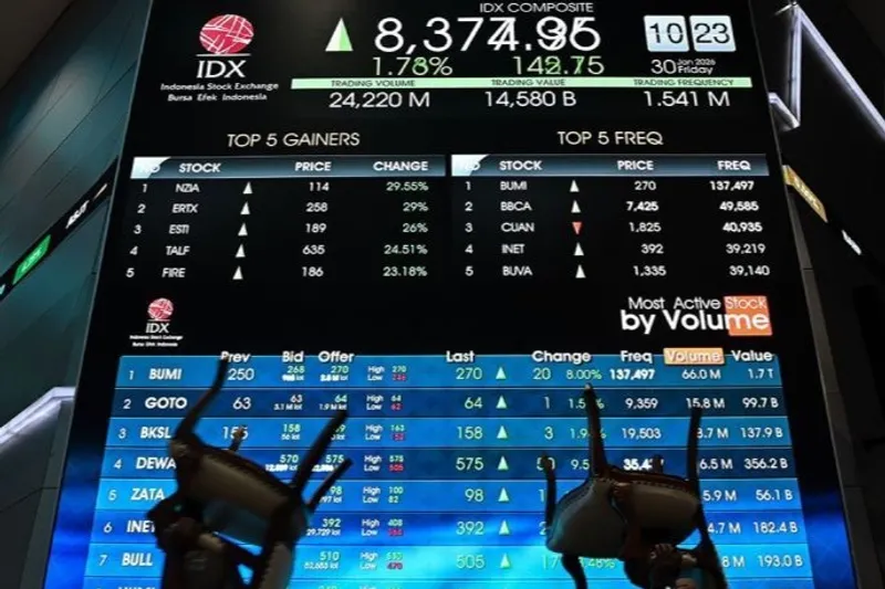 Pekerja mengangkut kursi di depan layar digital pergerakan Indeks Harga Saham Gabungan (IHSG) 
