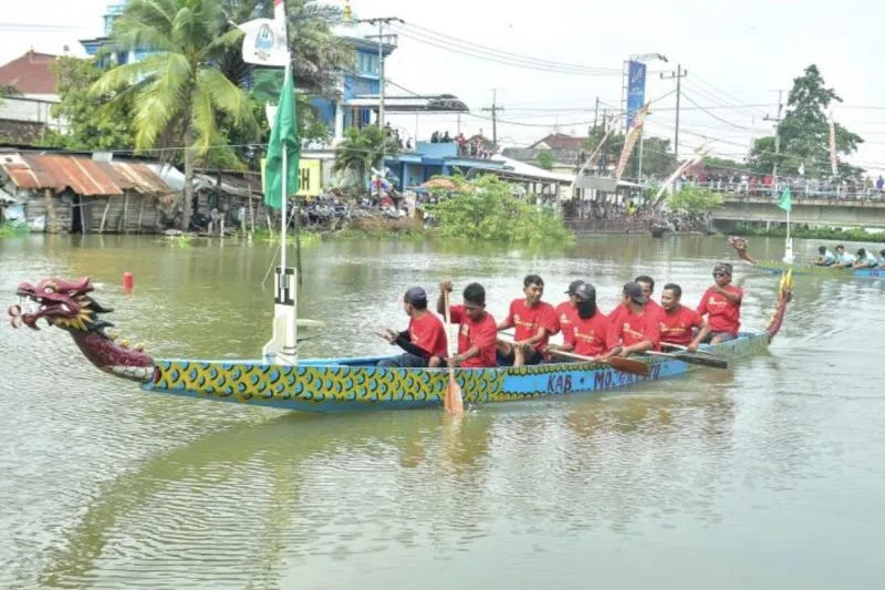 Peserta memacu perahu saat lomba dayung dragon boat di Bengawan Jero