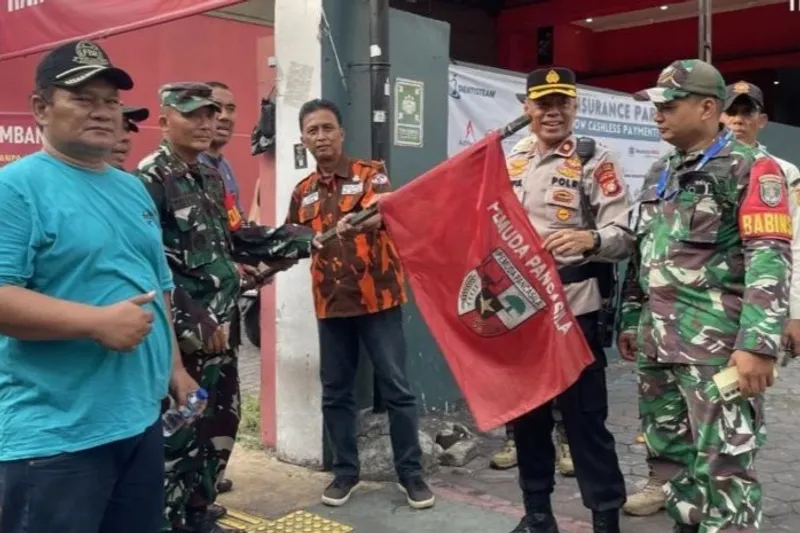 Petugas saat menurunkan bendera ormas di Jakarta