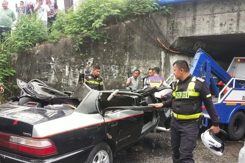 Petugas mengevakuasi mobil sedan yang terlibat kecelakaan dengan truk