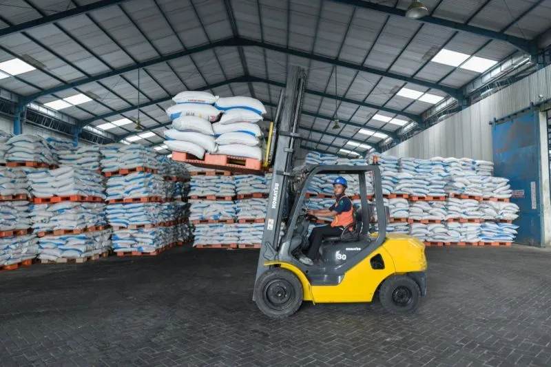Seorang pekerja mengangkut pupuk di gudang Pupuk Indonesia