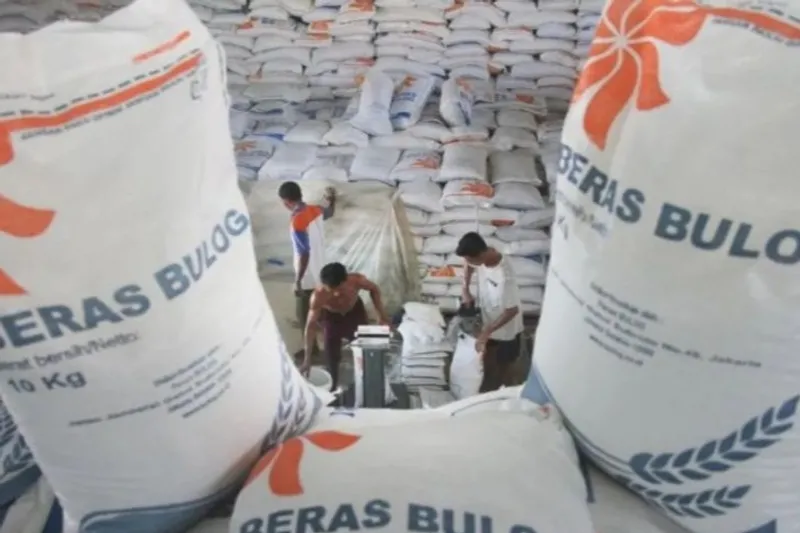Pekerja mengemas beras di gudang Perum Bulog Subdivisi Regional (Drive) Meulaboh