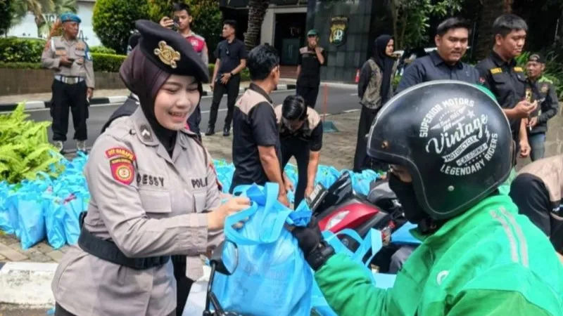anggota Polda Metro Jaya membagikan bantuan sembako kepada ojol dan buruh harian lepas 