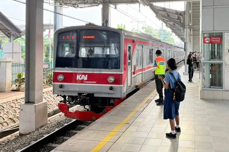 Seorang petugas mengawasi kedatangan KRL di peron stasiun