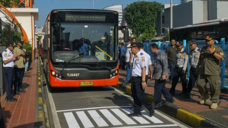 Warga melintas di depan bus Transjabodetabek