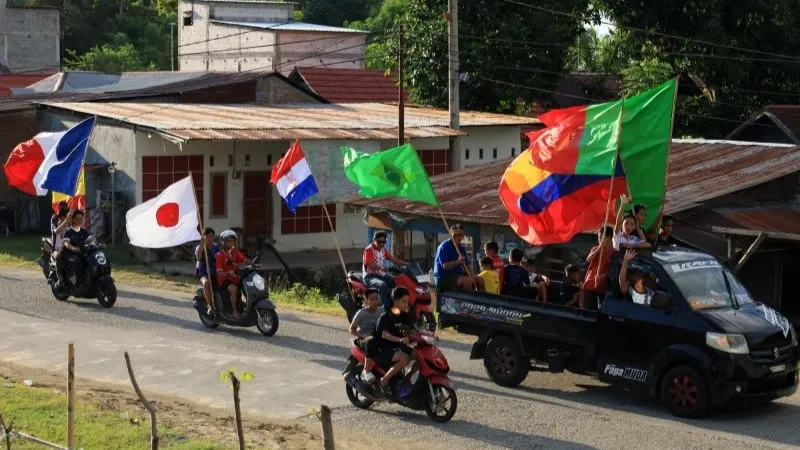 penggemar sepak bola berkonvoi sambil membawa bendera negara peserta Piala Dunia 2026