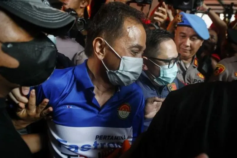 Petugas kepolisian menggiring Roy Suryo