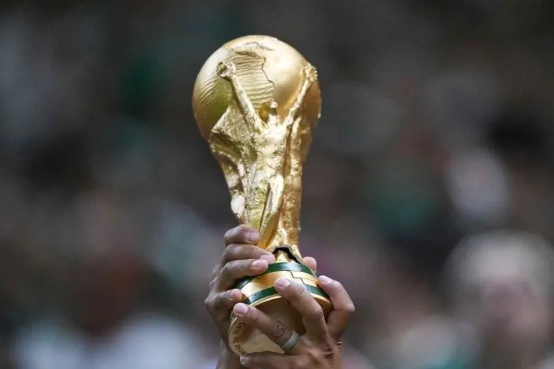 Seorang suporter mengangkat replika trofi Piala Dunia 