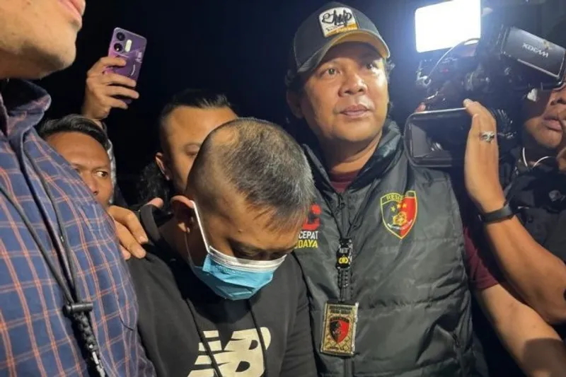 Petugas kepolisian saat menggiring Taufik Hidayat, tersangka penyekapan 