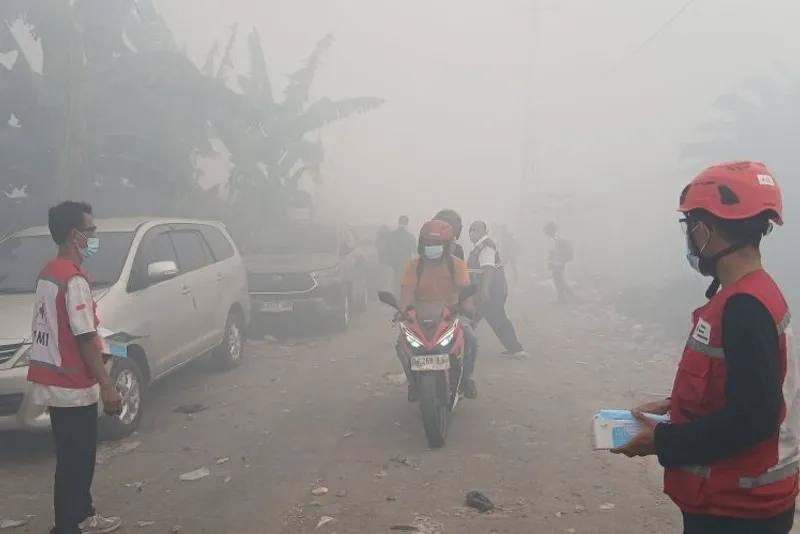 Petugas PMI membagikan masker kepada pengendara di sekitar lokasi kebakaran TPA Jatiwaringin Petugas PMI membagikan masker kepada pengendara yang melintas di sekitar lokasi kebakaran TPA Jatiwaringin, Kecamatan Mauk, Kabupaten Tangerang, Banten, Rabu (1/7/2026). ANTARA/Azmi Samsul M