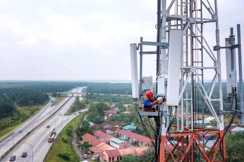 Seorang petugas sedang melakukan perbaikan di menara BTS 
