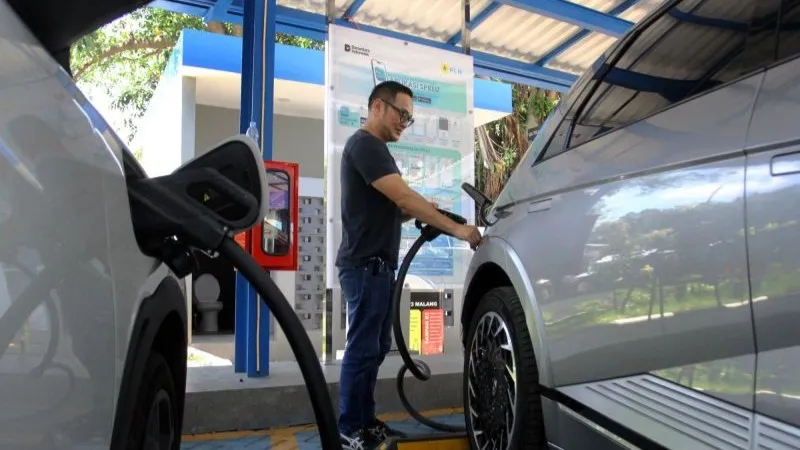 Pengguna kendaraan listrik mengisi daya di  SPKLU