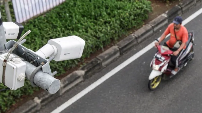 Pengendara sepeda motor melintas di bawah kamera pengawas atau Closed Circuit Television (CCTV) 