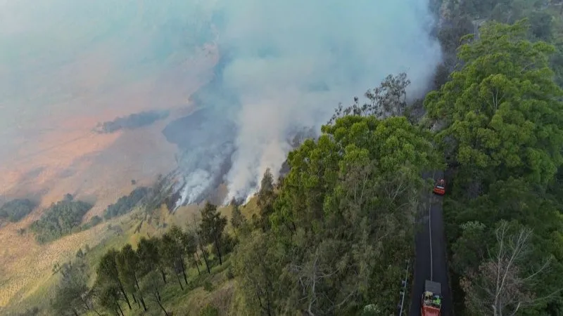 kendaraan pengangkut wisatawan melintasi kepulan asap dari kawasan Blok Bantengan Gunung Bromo