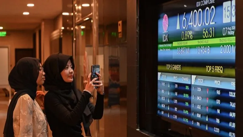 Pengunjung memotret layar pergerakan Indeks Harga Saham Gabungan (IHSG)
