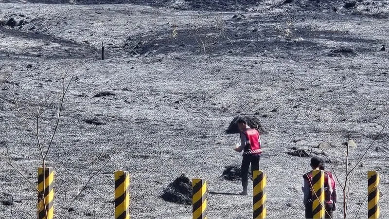 Personel kepolisian mengecek kondisi padang rumput terdampak kebakaran di Gunung Bromo