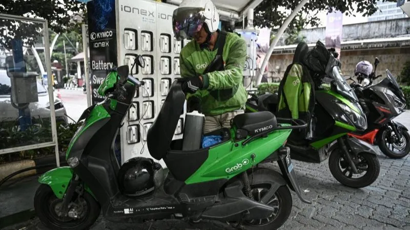 Pengemudi ojek daring mengganti baterai sepeda motor listriknya