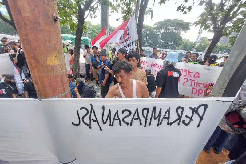 Massa menyiapkan atribut aksi di depan Gedung DPR