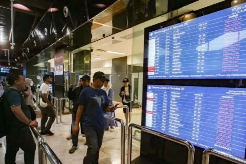 Calon penumpang melihat layar monitor jadwal penerbangan