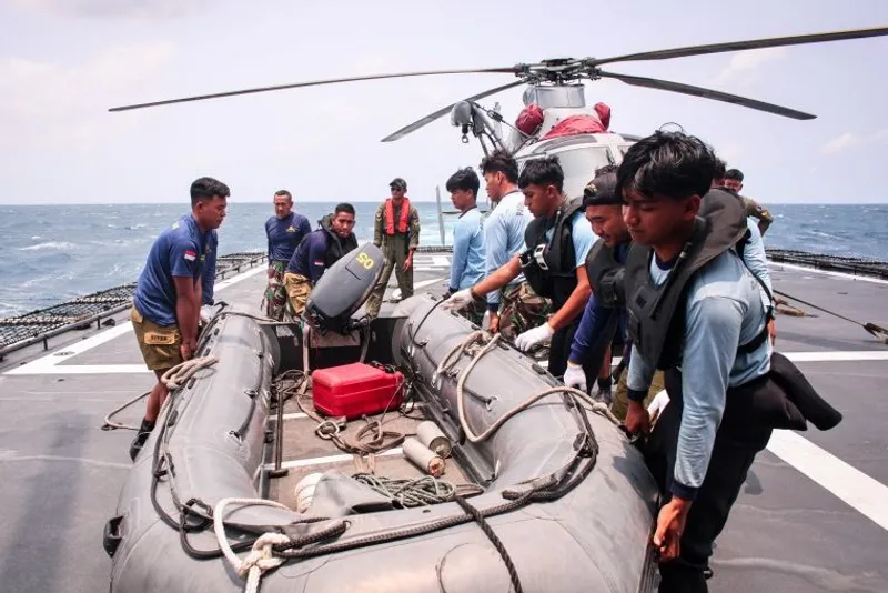Sejumlah personel TNI AL mengangkat perahu karet