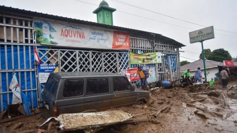 Warga mengecek kondisi kendaraan yang terendam  banjir bandang Solok