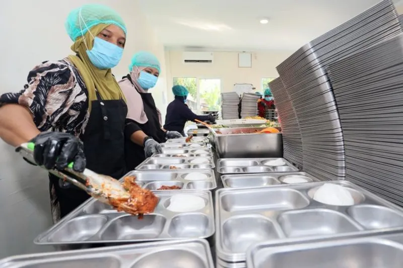 Petugas menyiapkan makanan Program Makan Bergizi Gratis (MBG) 