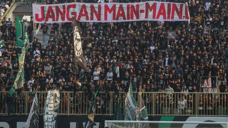  suporter membentangkan spanduk untuk mendukung tim PSS Sleman