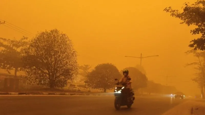 pengendara melintasi Jalan RTA Milono saat asap pekat akibat karhutla 